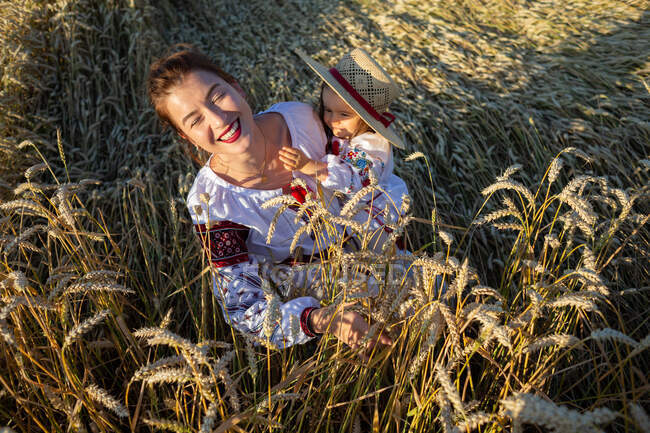 Мать с дочерью играют на пшеничном поле — стоковое фото