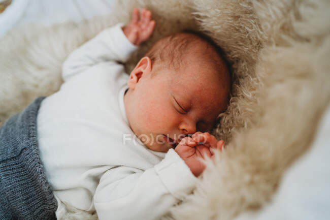 Adorabile neonato bianco che dorme nel cesto di Mosè con accogliente tappeto — Foto stock