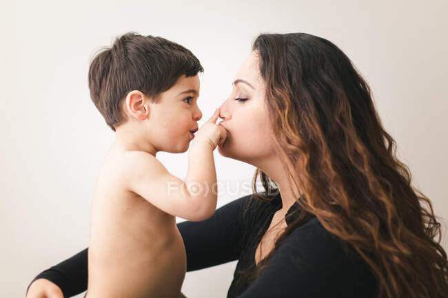 Retrato de una joven con un niño posando en el estudio - foto de stock