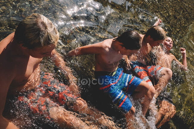 Niños poniendo el sol de California vistiendo trajes de baño coloridos - foto de stock