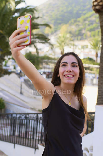 Jovem adolescente faz um auto-retrato com seu celular em um ci — Fotografia de Stock