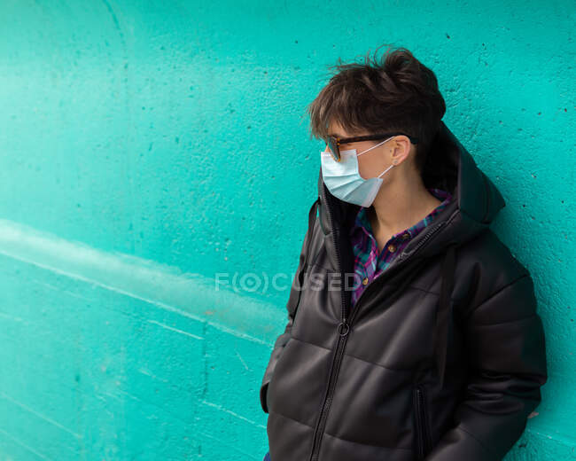 Kurzhaarige Frau mit Sonnenbrille, die zur Seite schaut auf einem hübschen blauen Hintergrund — Stockfoto