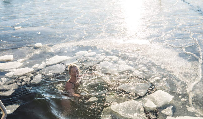 Mulher feliz Treading água com gelo no oceano na Dinamarca — Fotografia de Stock
