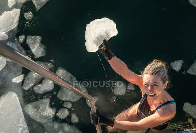 Glückliche Schwimmerin hält Eisbrocken aus eiskaltem Wasser in Kopenhagen — Stockfoto
