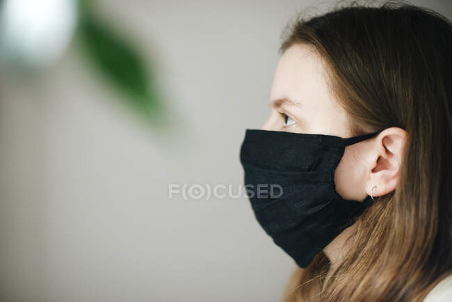 Young woman on the white background wearing a face mask — Stock Photo