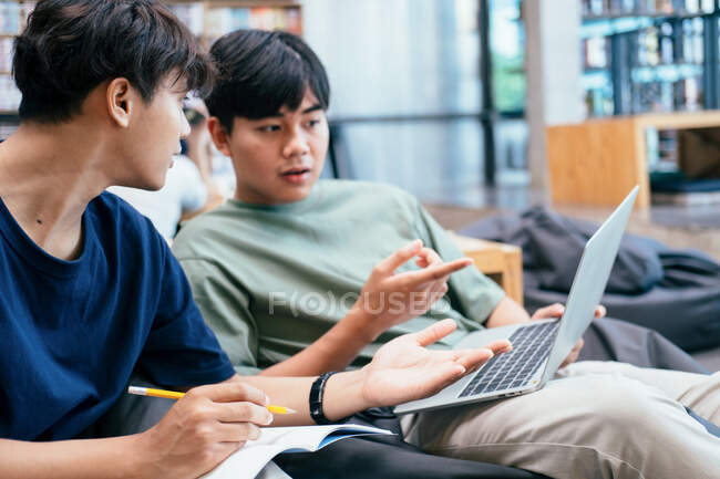 Learning, education and school concept. Young woman and man studying for a test or an exam. Tutor books with friends. Young students campus helps friend catching up and learning. — Stock Photo