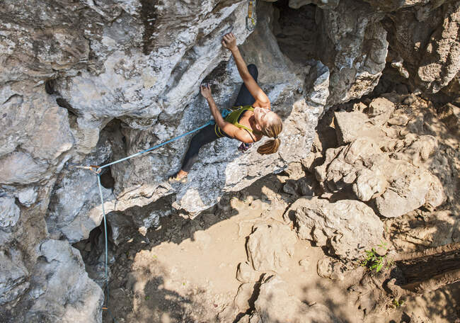 Woman climbing steep limestone cliff in Laos — Stock Photo