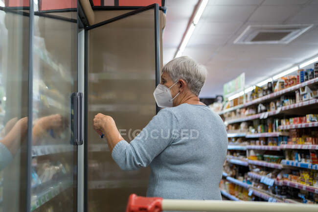 Caucasian elderly woman with face mask shopping in supermarket — Stock Photo