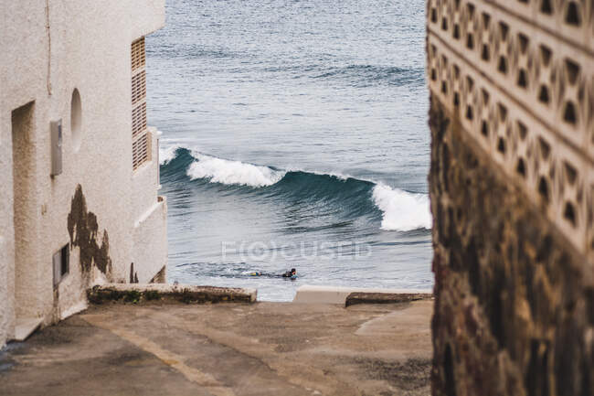 Bodyboarder geht ins Wasser und beobachtet eine Welle brechen, Haus, surfen — Stockfoto