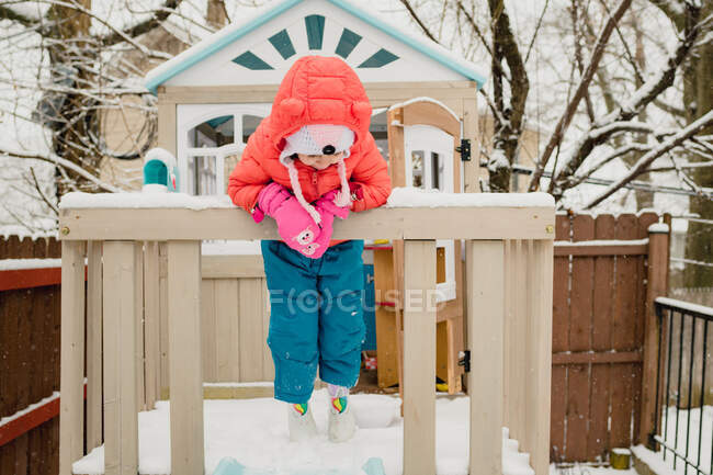 Young child playing in play house in snow storm — Stock Photo