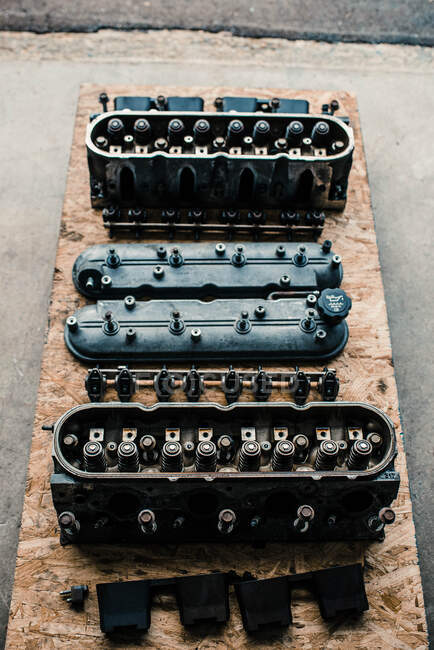 Overhead view of valve covers, rockers, and heads in a mechanics shop — Stock Photo