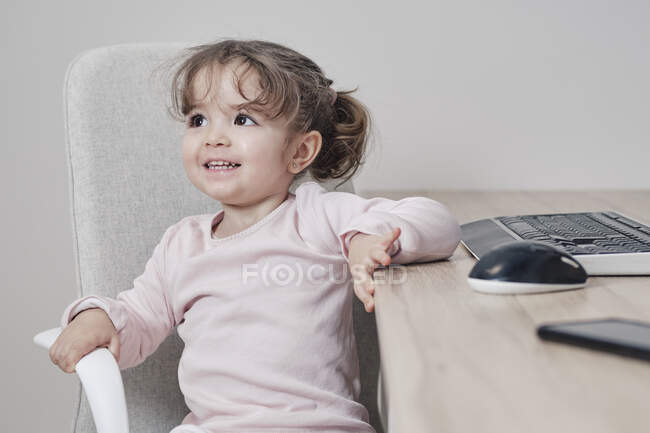 Una niña de 2 años está usando un teclado de computadora - foto de stock