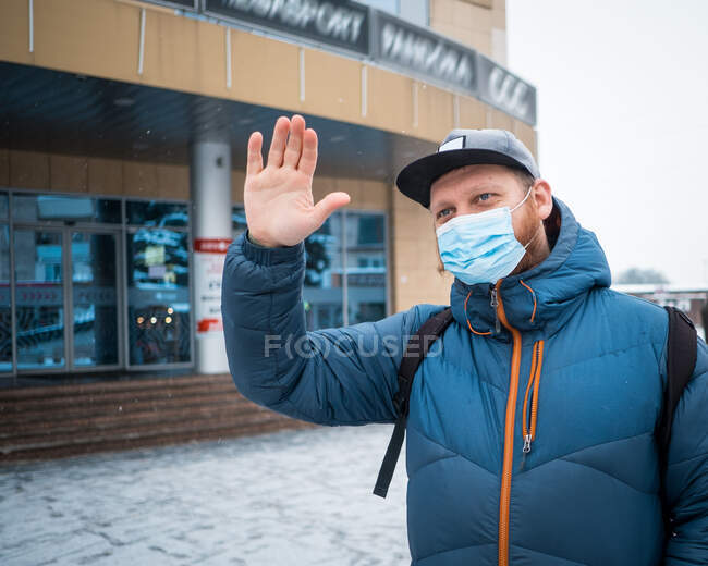 Hombre con máscaras anti virus saludando a sus amigos - foto de stock
