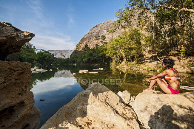 Jeune femme relaxant par th elake en été — Photo de stock