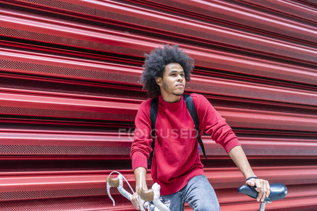 Joven con pelo afro con su bicicleta - foto de stock