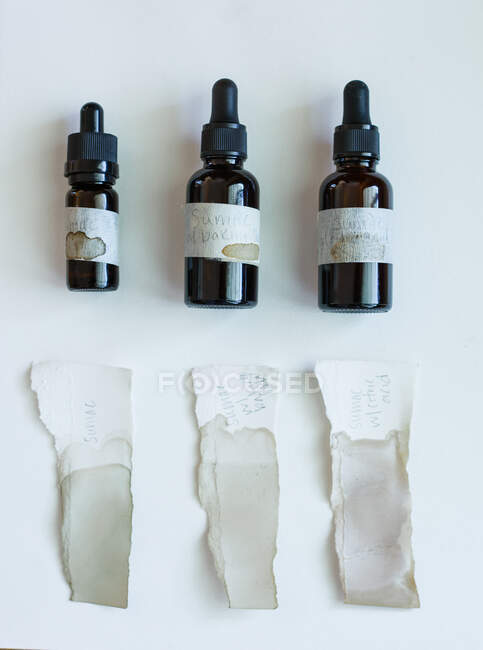 Échantillons de couleur encre dans des bouteilles compte-gouttes en verre ambré sur un fond blanc — Photo de stock