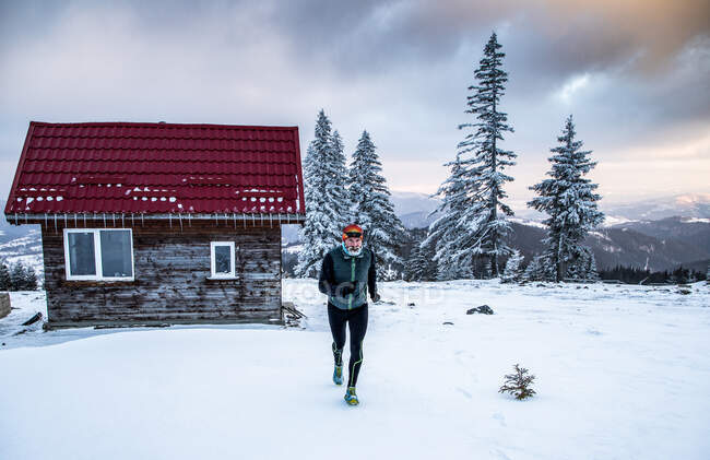 Trail runner in extreme weather in winter mountains — Stock Photo