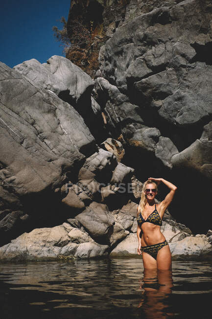 Tan Woman im Bikini steht an einem Sommertag im Fluss — Stockfoto