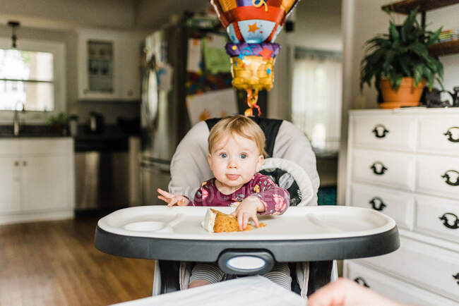 Um ano de idade comemorando aniversário com a família à mesa com bolo — Fotografia de Stock