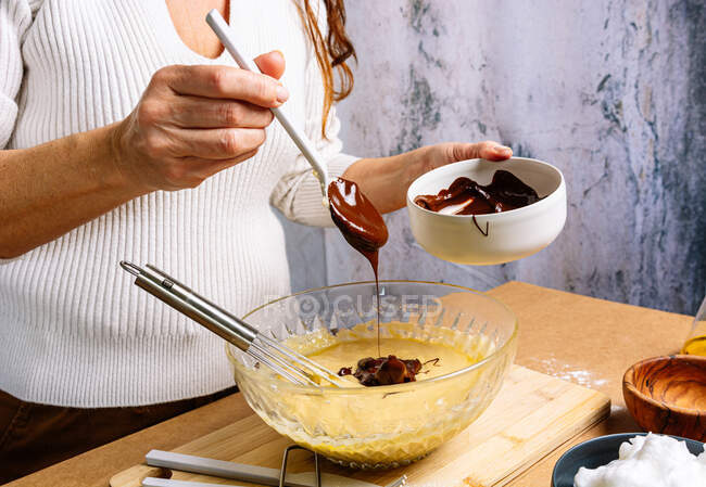 Femme préparant et cuisinant un gâteau au chocolat éponge. Concept de cuisine traditionnelle et pâtissière — Photo de stock