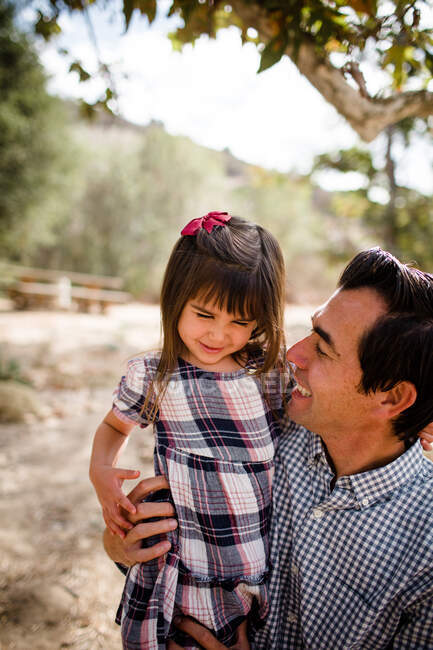 Papá cosquillas hija joven en el parque en San Diego - foto de stock