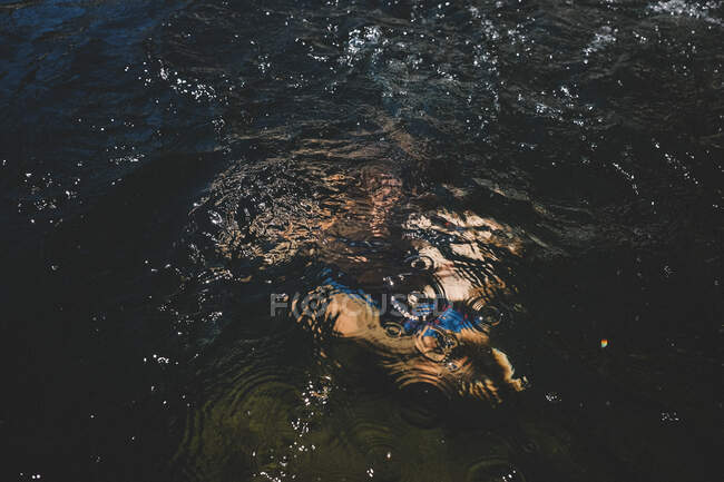 Blurred Figure Under the Surface with Ripples and Bubbles — Stock Photo
