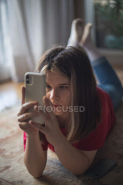 Un'adolescente guarda lo schermo del suo smartphone — Foto stock
