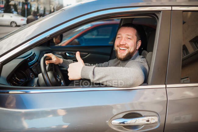 Чоловік посміхається в машині. — стокове фото