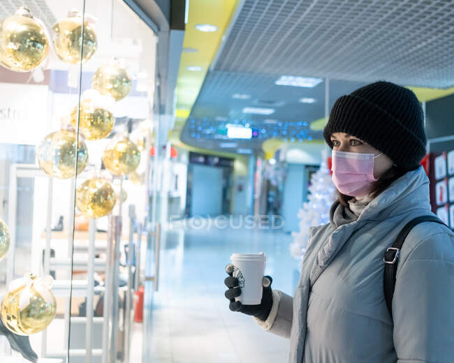 Mujer en un centro comercial vacío durante covid-19 - foto de stock