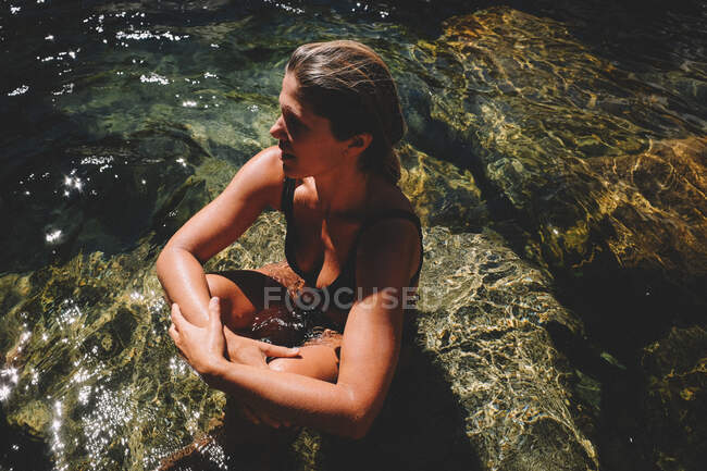 Mulher se senta nas águas claras do rio Yuba no verão — Fotografia de Stock