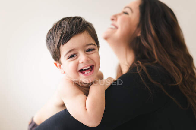 Retrato de una joven con un niño posando en el estudio - foto de stock