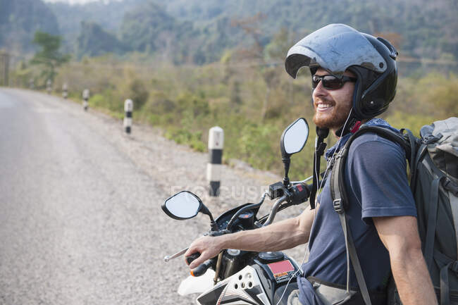 Молодой человек на мотоцикле в Лаосе — стоковое фото