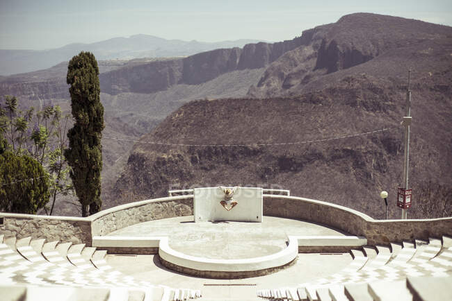 Танцівниця піднімається в геометричному амфітеатрі з видом на пустельний сонячний хребет — стокове фото