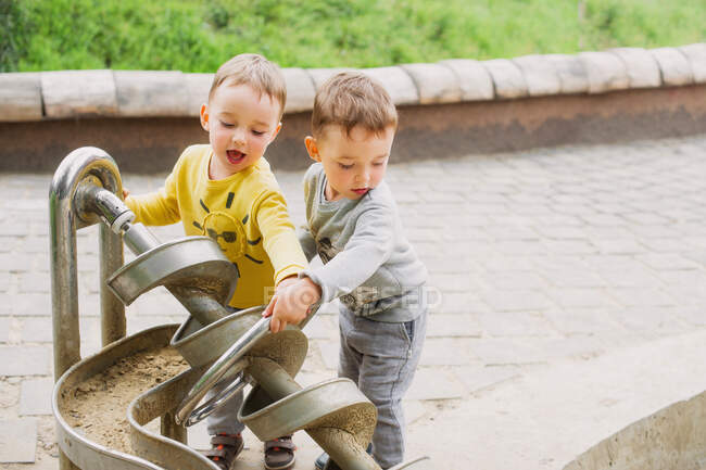 Twin brothers explore the metal construction of the Archimedes screw — Stock Photo
