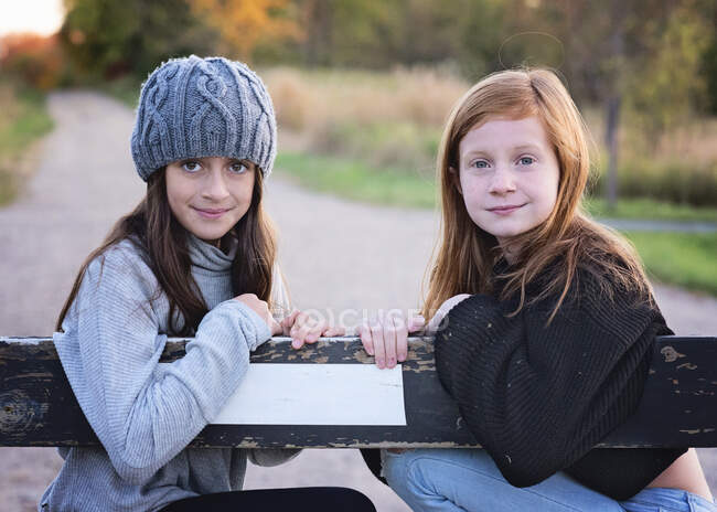 Two young tween girls in sweaters outdoors on country road. — Stock Photo