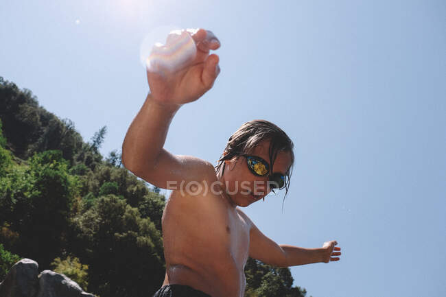 Tween muchacho en gafas que gotean el agua en un día medio del verano - foto de stock