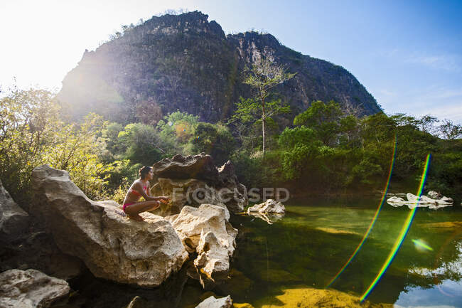 Jeune femme relaxant par th elake en été — Photo de stock