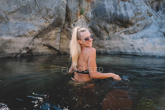 Tan Blond Woman With Ponytail and Sunglasses Smiles Back at the Camera — стокове фото