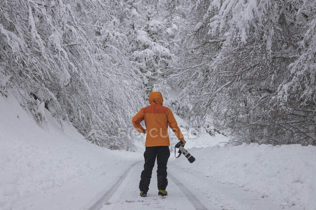 Man walking on mountain trail with camera — Stock Photo
