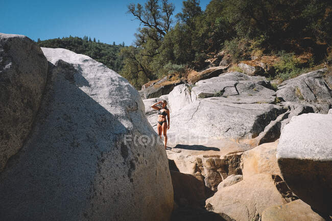 Жінка в купальнику захищає очі від сонця — стокове фото