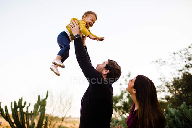 Familia feliz con la niña divirtiéndose en el parque - foto de stock