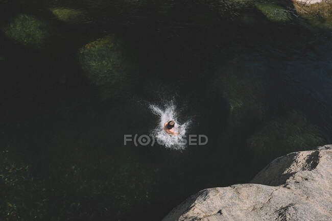 Мальчик создает перфектный всплеск в темных водах реки Юба — стоковое фото