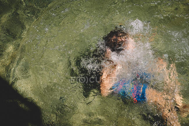 Хлопчик, занурений під воду, робить бульбашки. — стокове фото