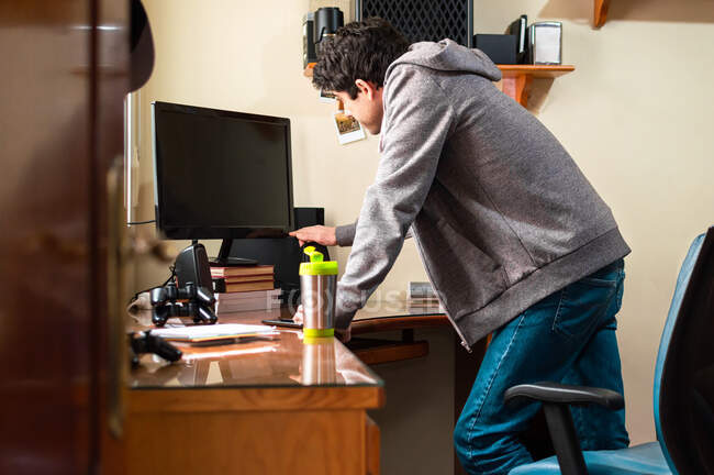 Homem de camisola acendendo a televisão de seu quarto para jogar videogames. — Fotografia de Stock