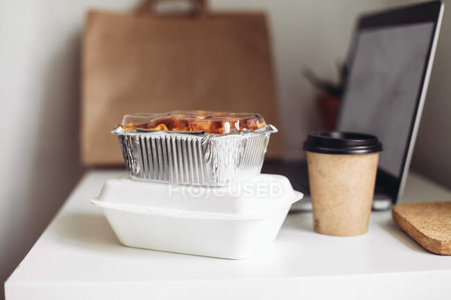 Take away coffee cup, delivery boxes, craft bag and a laptop at home — Stock Photo