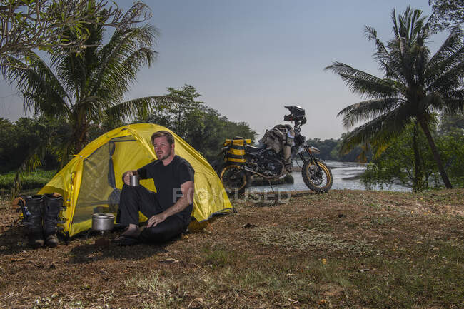 Giovane nella tenda vicino al motociclo — Foto stock