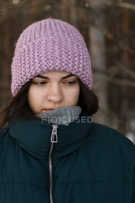 A sad girl in a pink hat looks away and thinks about something. — Stock Photo
