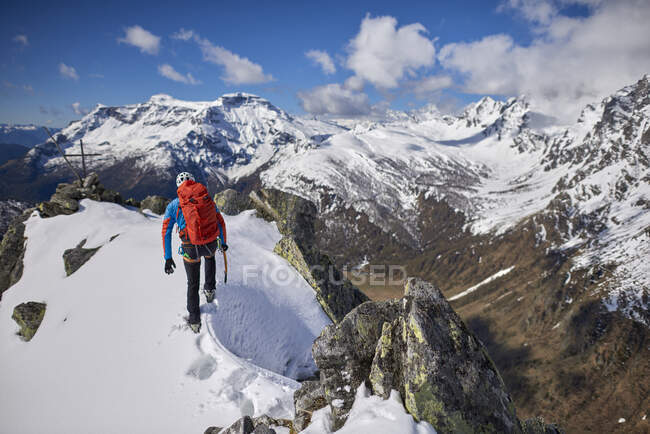 Mann besteigt einen schneebedeckten Berg an einem sonnigen Tag in Devero, Italien. — Stockfoto
