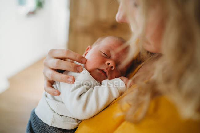 Close up of white newborn baby sleeping in mom's arms — Stock Photo