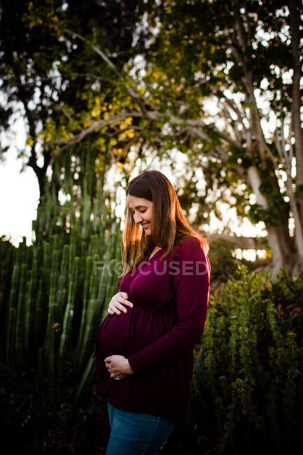 Femme enceinte posant dans le parc — Photo de stock